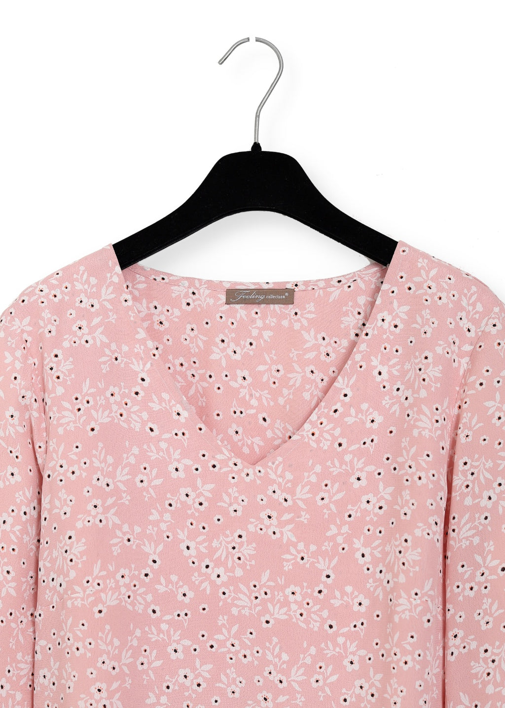 Detalj på Viskos klänning med volanger i rosa en känsla av lyxig elegans. Ärmarna med extra vidd ger en fin inramning. 