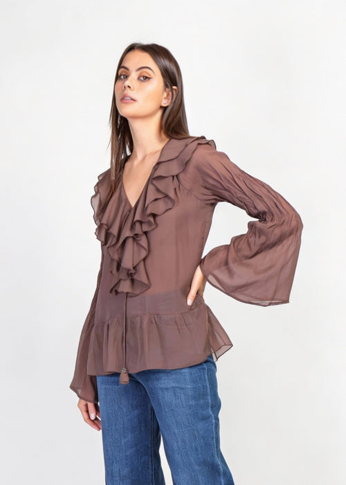 Blus med volanger i siden